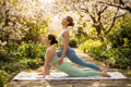 Women doing partner yoga on spring mats