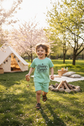 Child wearing Happy Camper short set at spring campsite